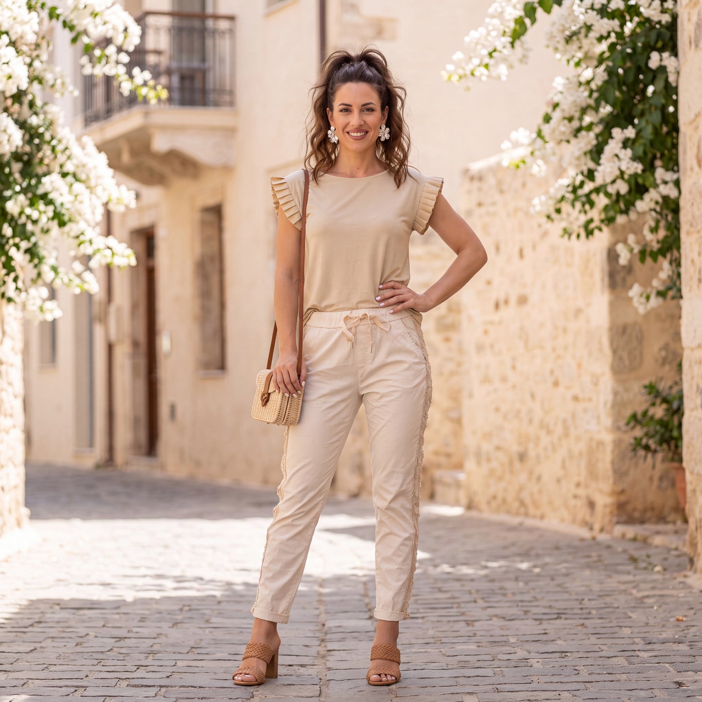 Woman wearing the Amalfi Ruffle Sleeve Top in Soft Vanilla Cream styled outdoors with casual summer fashion.