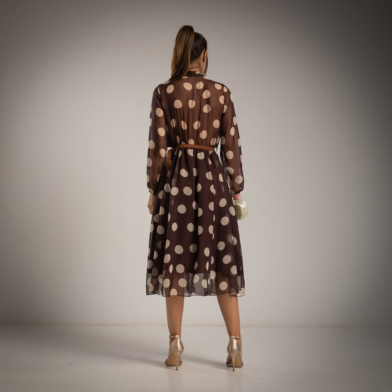 Back view of MARIΓIOÚ brown polka dot midi dress with sheer long sleeves and flowy skirt – Italian-made fashion.