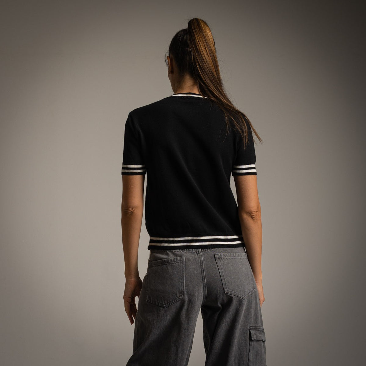 Black short sleeve knit sweater with contrast striped trims - back view