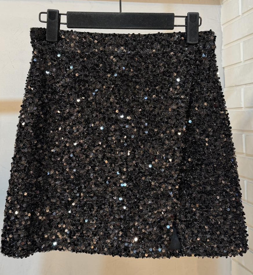 Front view of elegant black sequin mini skirt with shimmering sequins and side slit.
