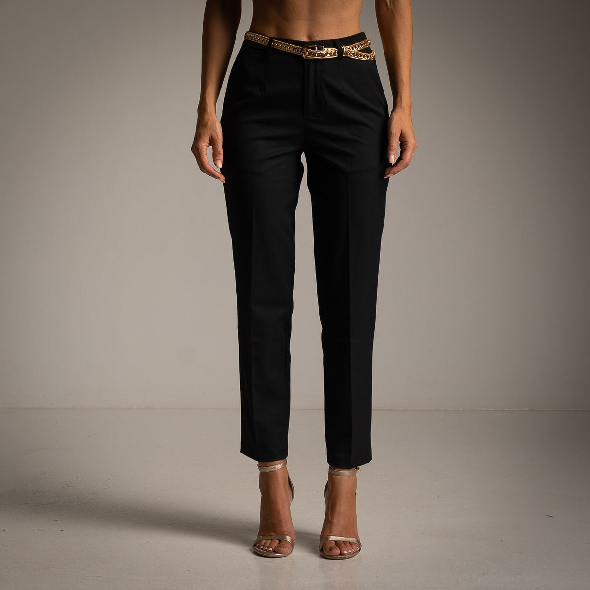 Black tailored cropped trousers with pressed crease and slim tapered leg - front view