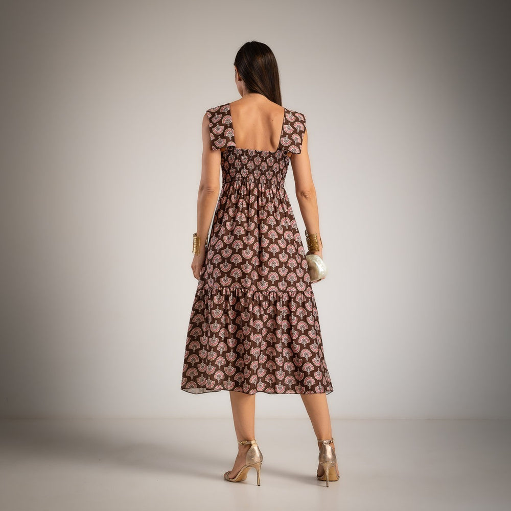 Back view of a chocolate fan print midi dress featuring an elasticated back and flowing skirt