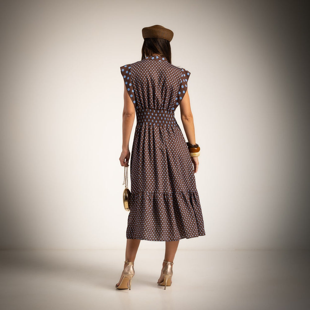 Back view of chocolate brown polka dots midi dress with elastic waist and flowing midi skirt