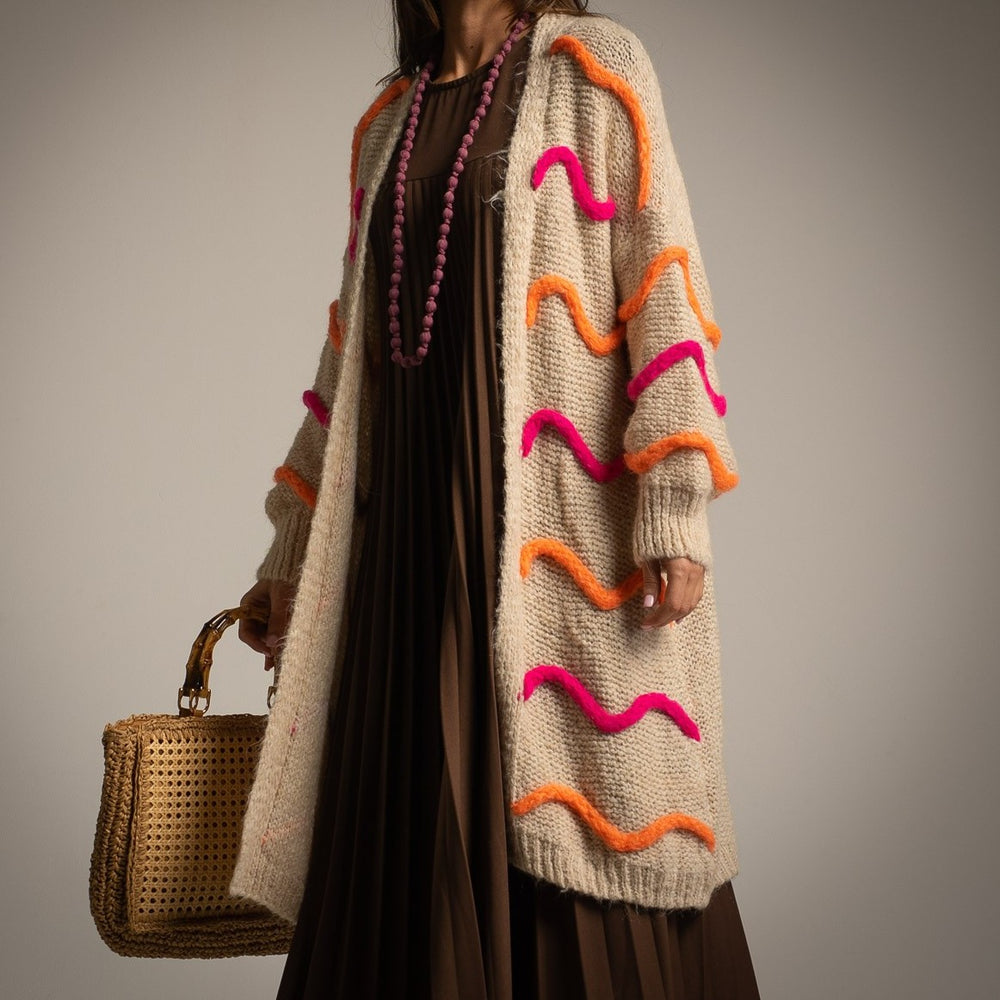 Beige long alpaca-wool cardigan with pink and orange wave details – close-up | MARIΓIOÚ