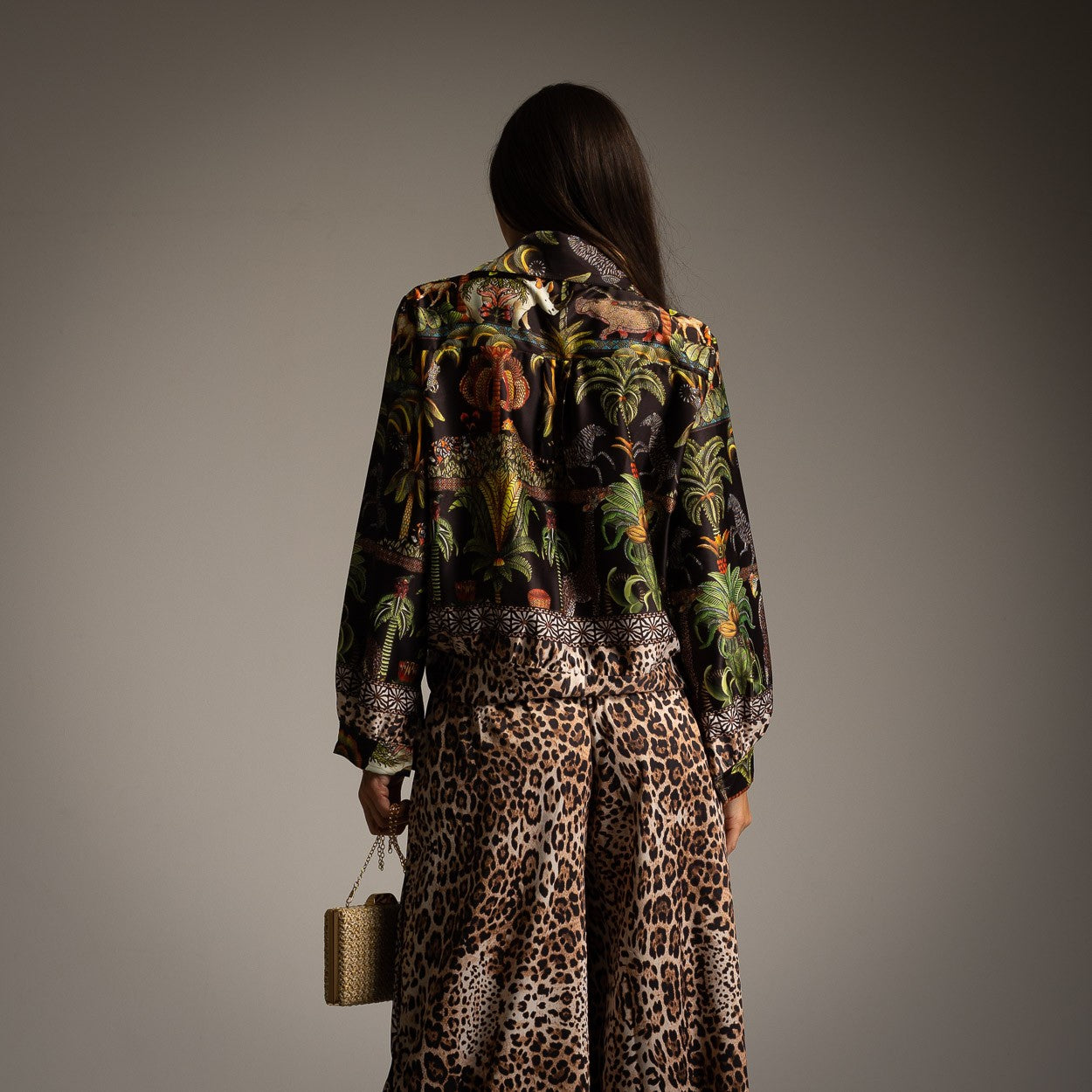 Back view of classic black safari print shirt with jungle-inspired pattern and leopard print wide-leg trousers