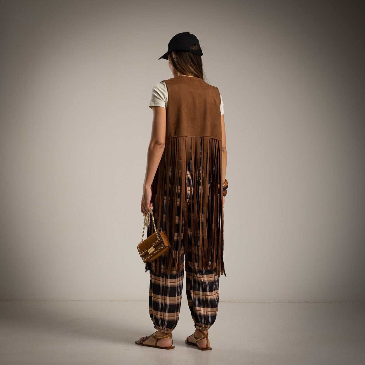 Back view of a brown suede vest with long fringe detail.