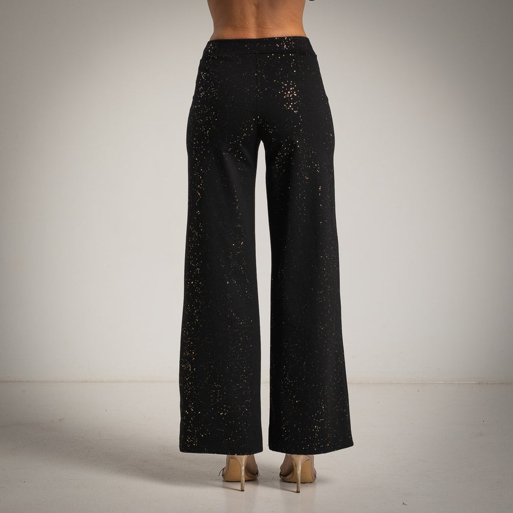 Black high-rise flared pants with scattered golden glitter foil - back view