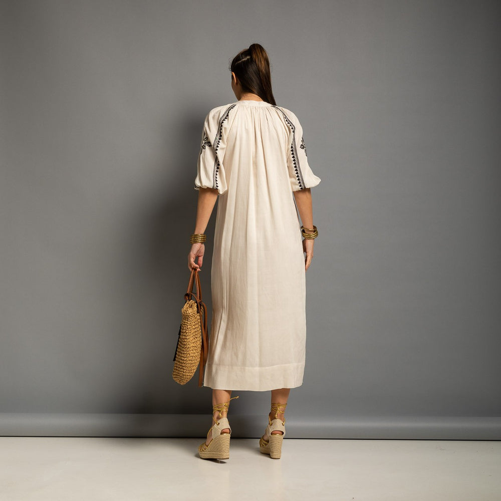 Back view of an embroidered ivory midi dress with relaxed fit and elegant balloon sleeves.