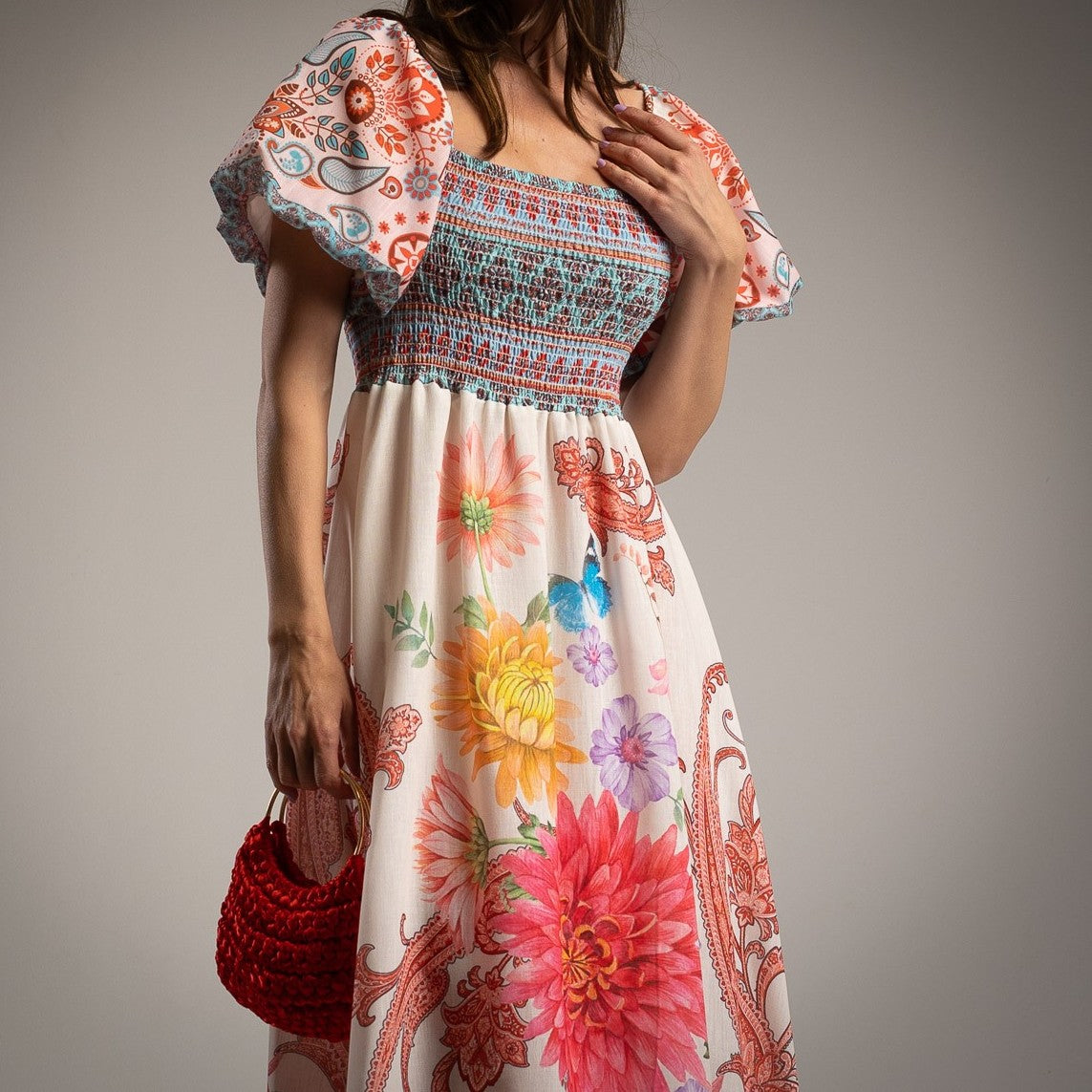 Close-up of MARIΓIOÚ floral linen blend midi dress with puff sleeves and smocked bodice, showcasing colorful flower print and detailed texture