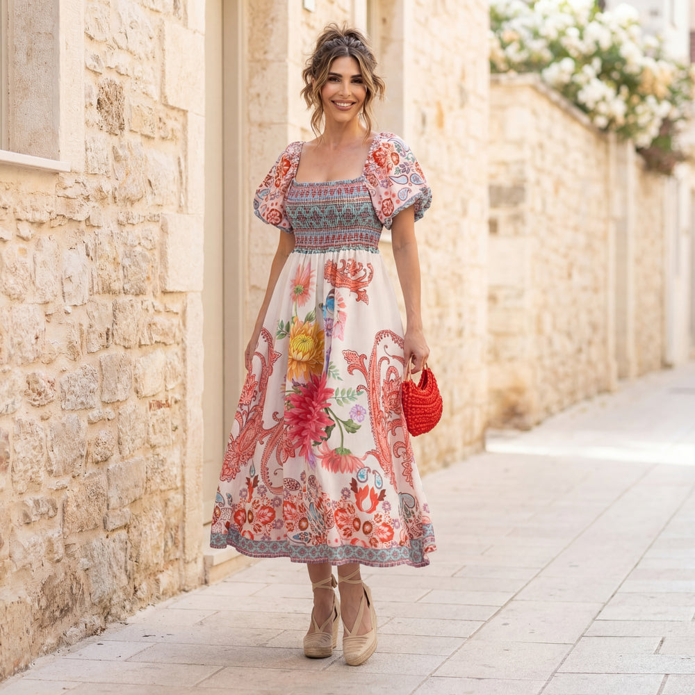 MARIΓIOÚ floral linen blend midi dress with puff sleeves, styled outdoors in a Mediterranean stone alley with espadrille wedges and red handbag