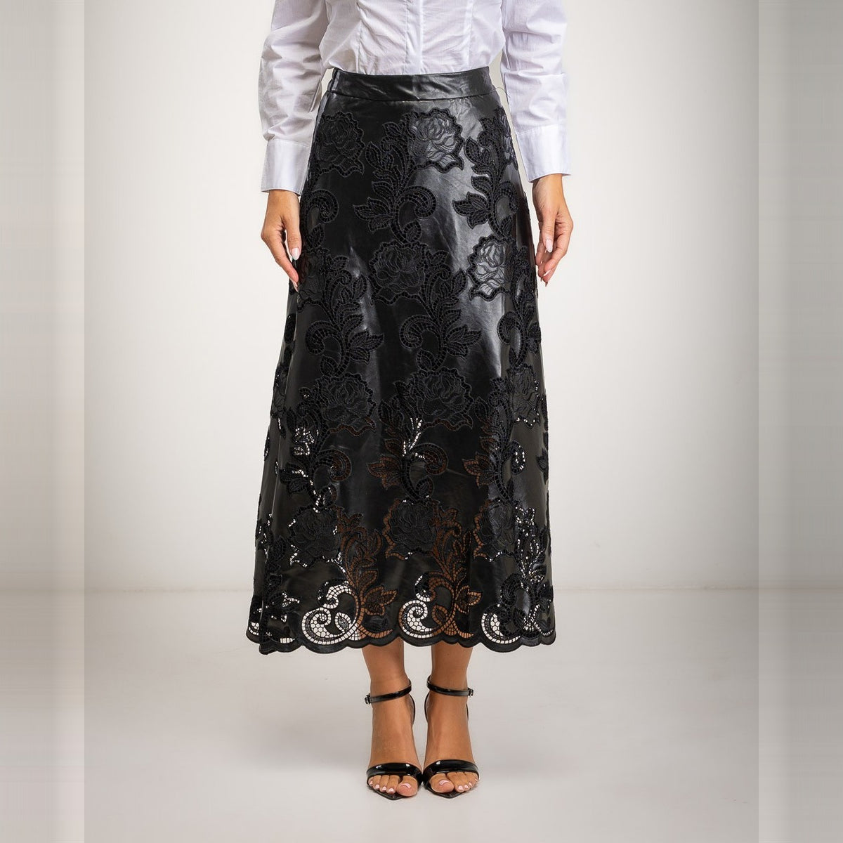 Black laser-cut floral faux leather midi skirt with scalloped hem - front view