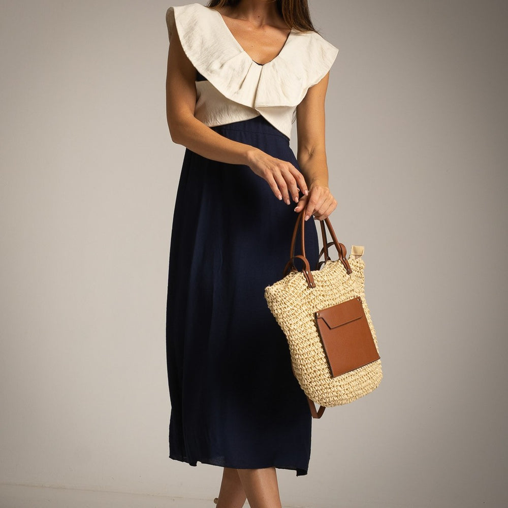 Close-up of Midnight Blue resort midi dress with straw tote bag styling