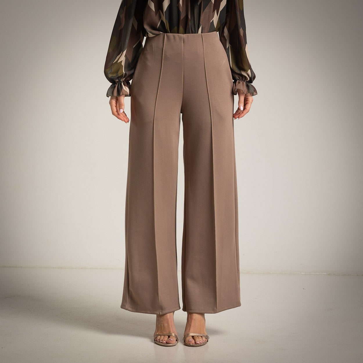 Almond Taupe high-waisted flared trousers with a pressed centre seam - front view