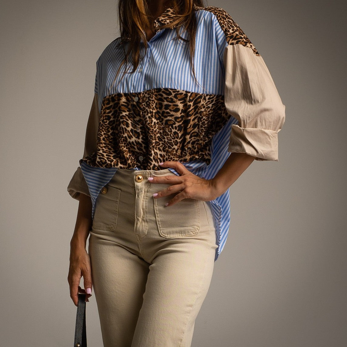 Front detail of MARIΓIOÚ leopard and striped oversize blouse styled with beige trousers