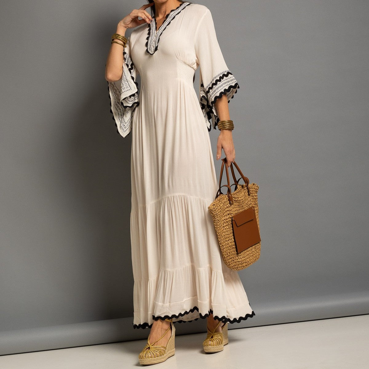 Elegant ivory boho maxi dress featuring a functional front button neckline, flowing bell sleeves and lace-inspired contrast trim.