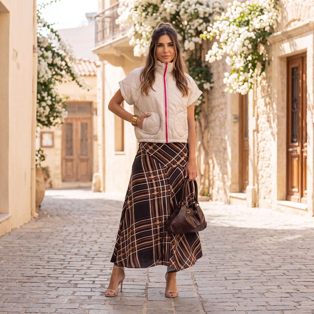 Woman wearing the MARIGIOU Padded Vest in Soft Vanilla Cream styled outdoors with an elegant autumn outfit.