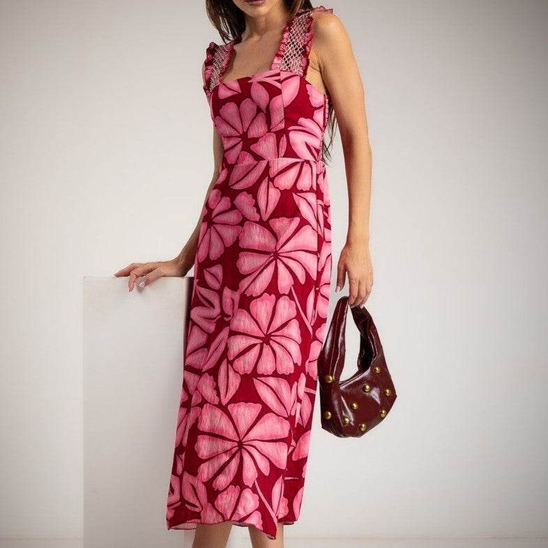 Woman wearing a pink floral midi dress with ruffle straps and square neckline, styled with a burgundy handbag