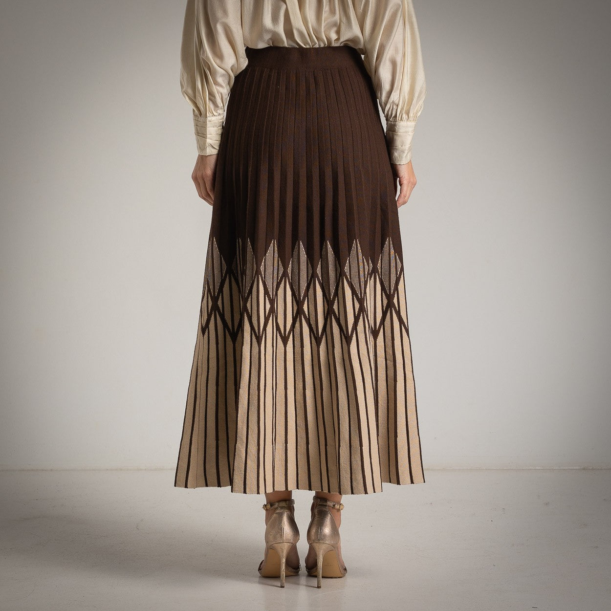 Chocolate pleated knit skirt with geometric pattern – back view