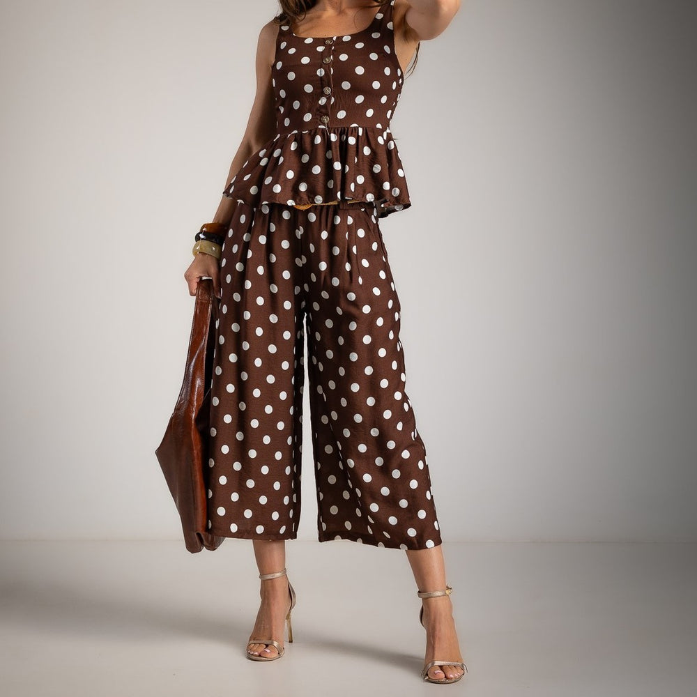 Front detail of chocolate brown polka dot peplum top with decorative buttons