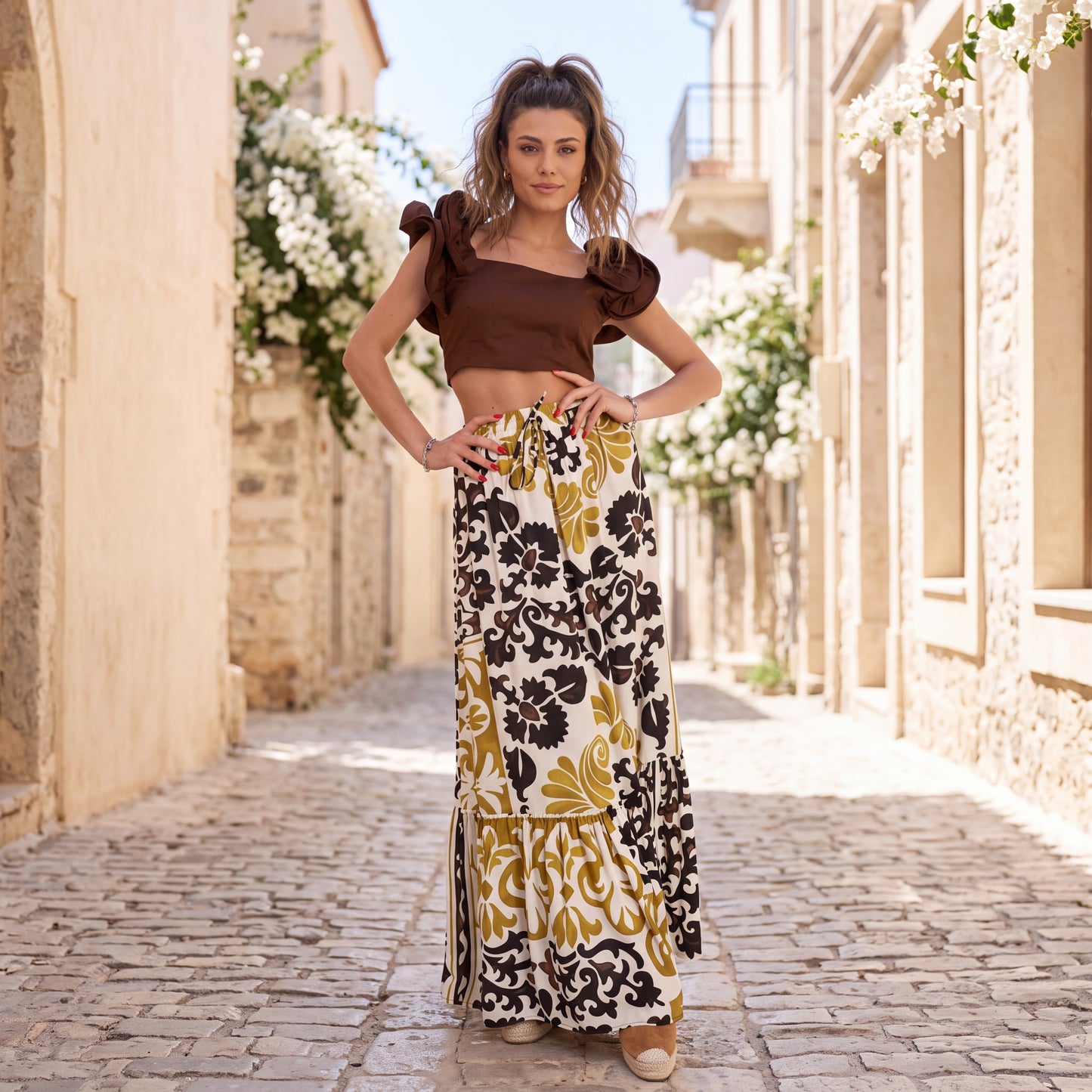 Printed maxi skirt styled with brown crop top in Mediterranean summer setting