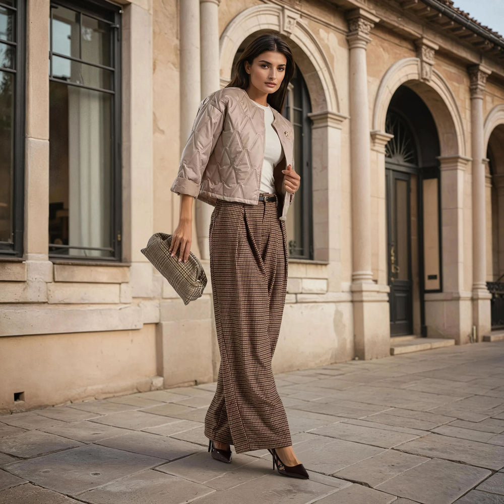 Beige quilted jacket with clover brooch styled with checked pants