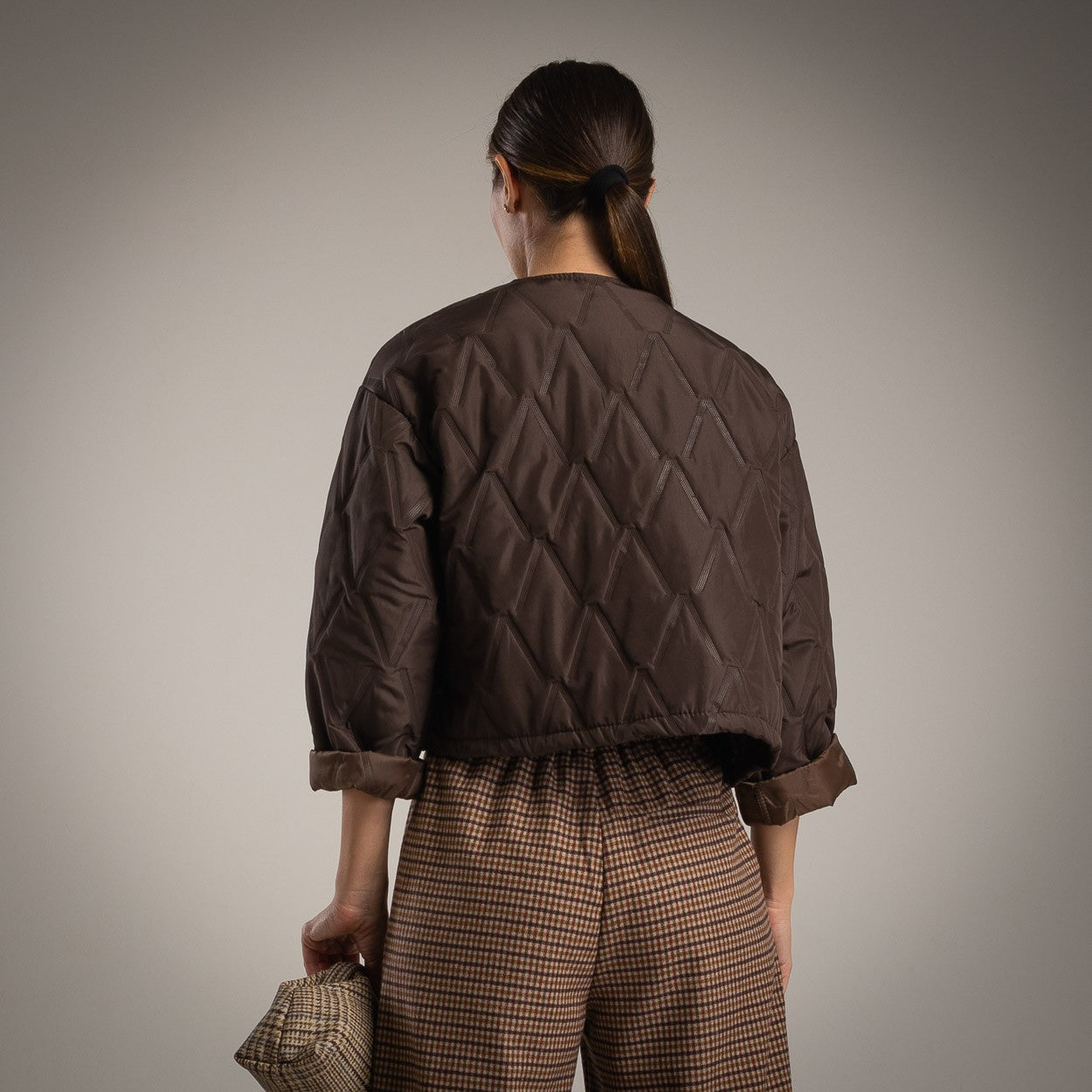 Chocolate quilted jacket with clover brooch back view