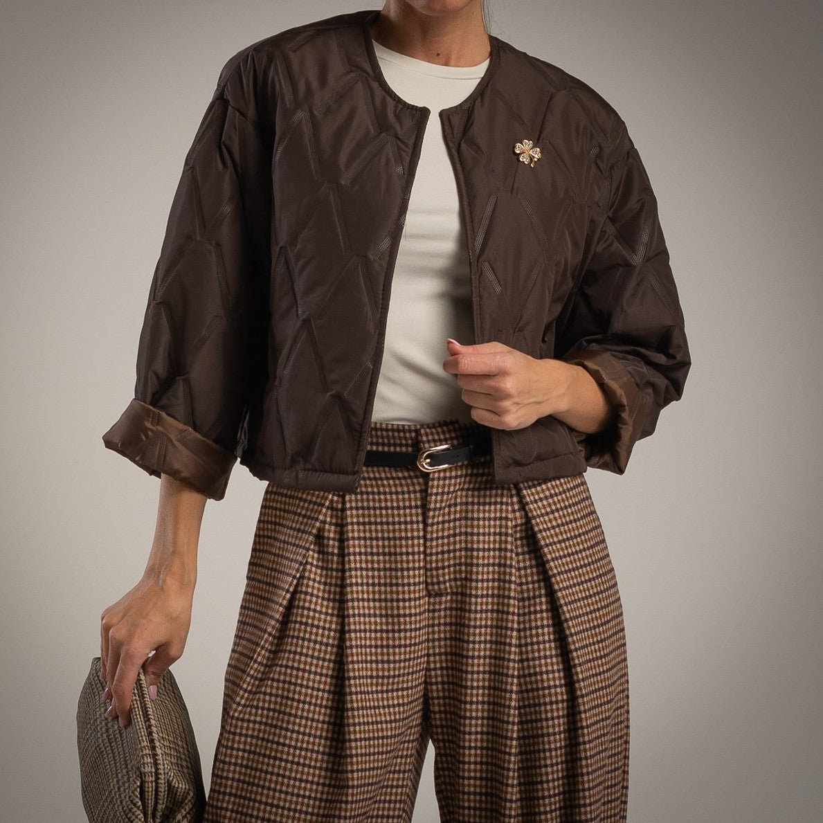 Chocolate quilted jacket with clover brooch front view