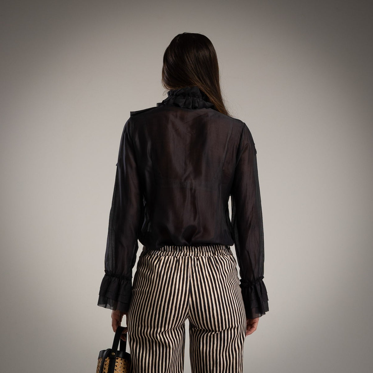 Black ruffle blouse with tie bow neck and flounced cuffs - back view