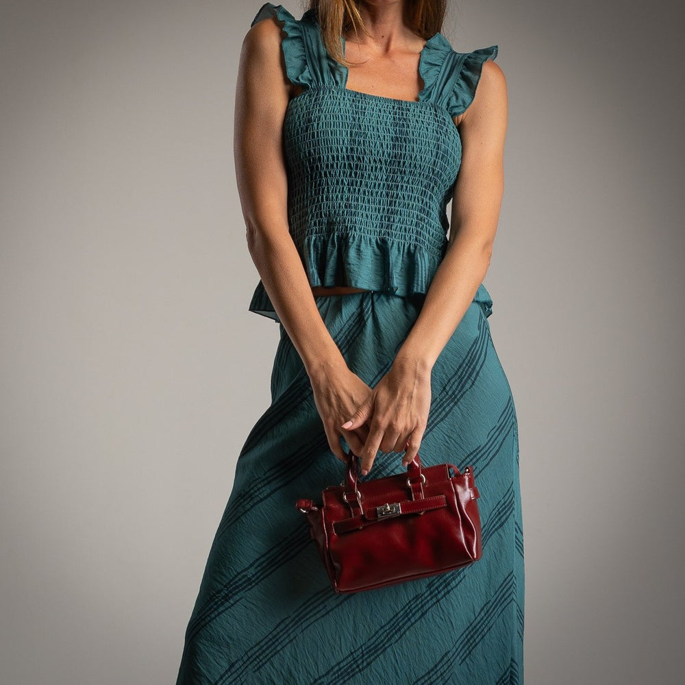 Detail view of petrol blue smocked ruffle top and matching midi skirt set