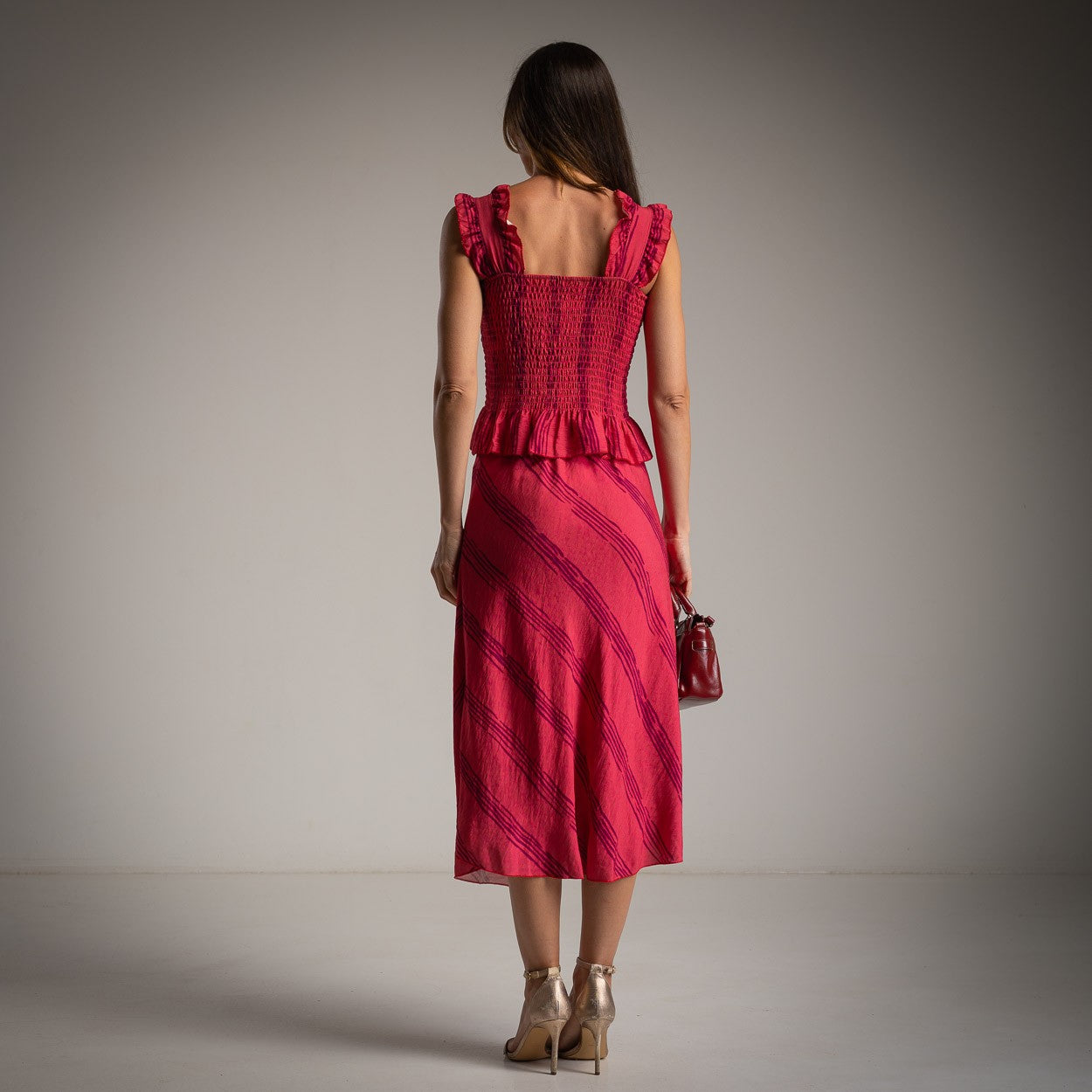 Raspberry pink two-piece set with smocked ruffle top and midi skirt, back view