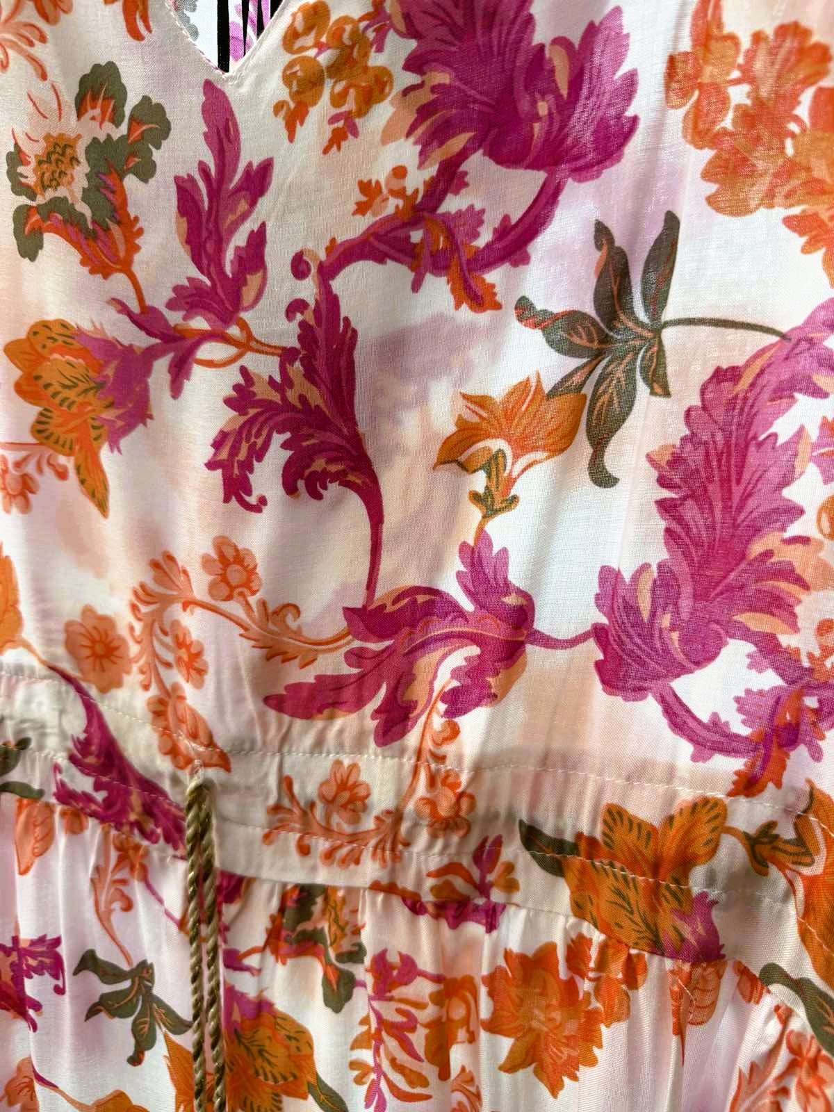 Close-up of the pink and orange floral print with tassel tie detail on the Santorini Bloom tunic