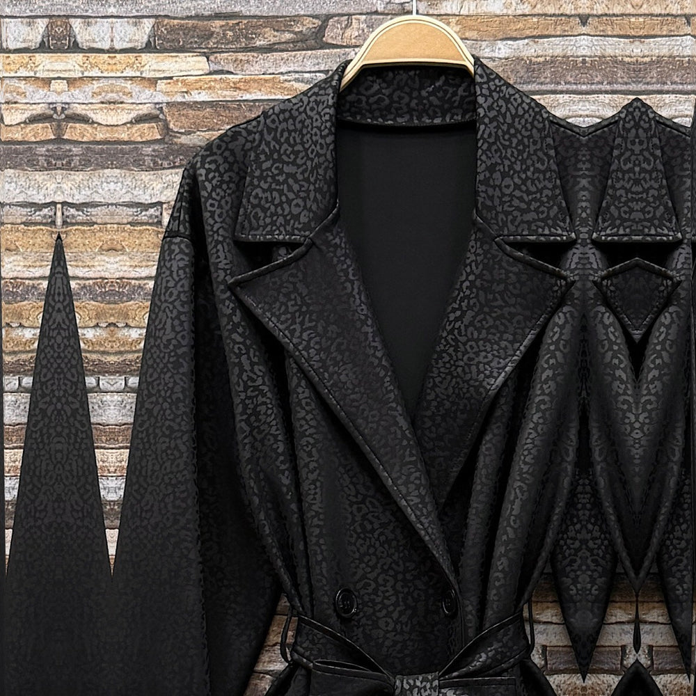 Black embossed leopard trench coat with wide lapels and tie belt - detail view