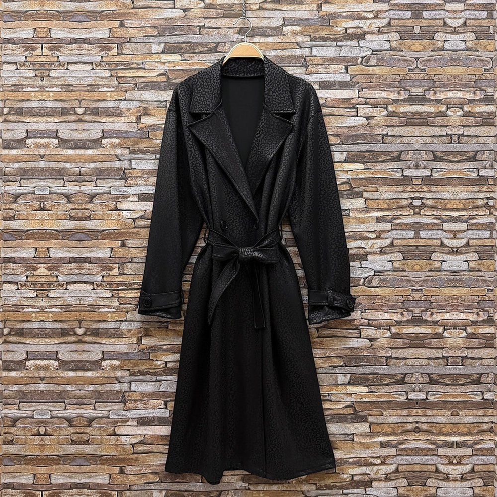 Black embossed leopard trench coat with wide lapels and tie belt - front view