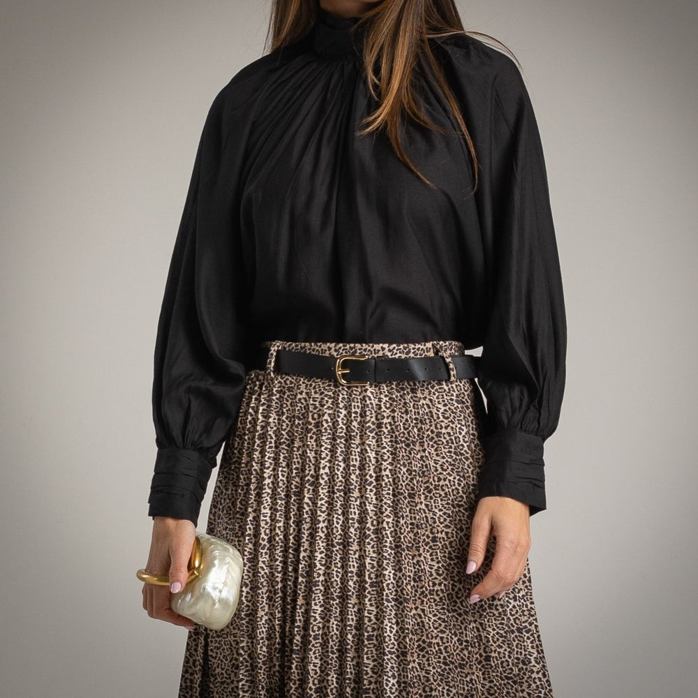 Black silk effect blouse styled with pleated skirt – detail view