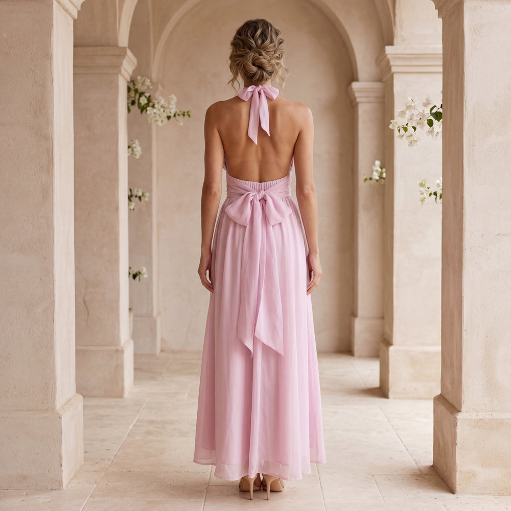 Back view of soft blush rose halterneck chiffon maxi dress with open back and bow detail