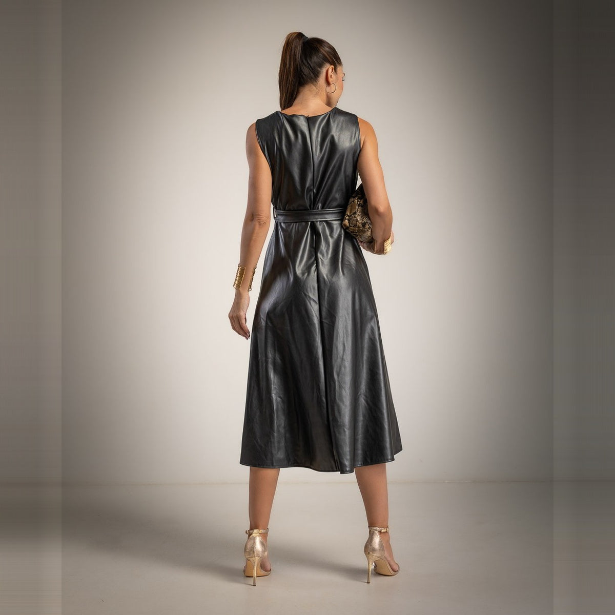 Black sleeveless faux leather midi dress with self-tie belt and flared skirt - back view