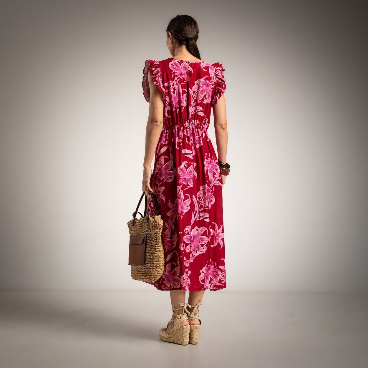 Back view of elegant floral midi dress in sunset fuchsia with flowing silhouette and pink floral print
