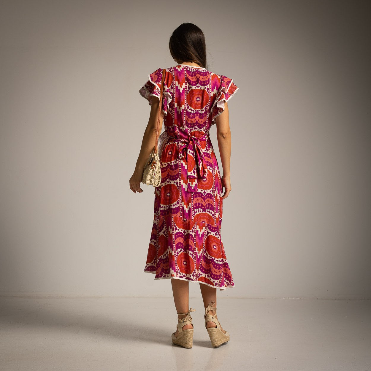 Back view of Sunset Fuchsia wrap midi dress with feminine summer silhouette