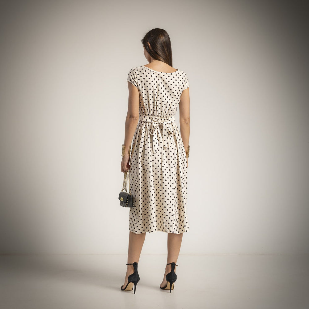 Back view of elegant polka dot midi dress in vanilla beige with adjustable waist detail and flowing skirt