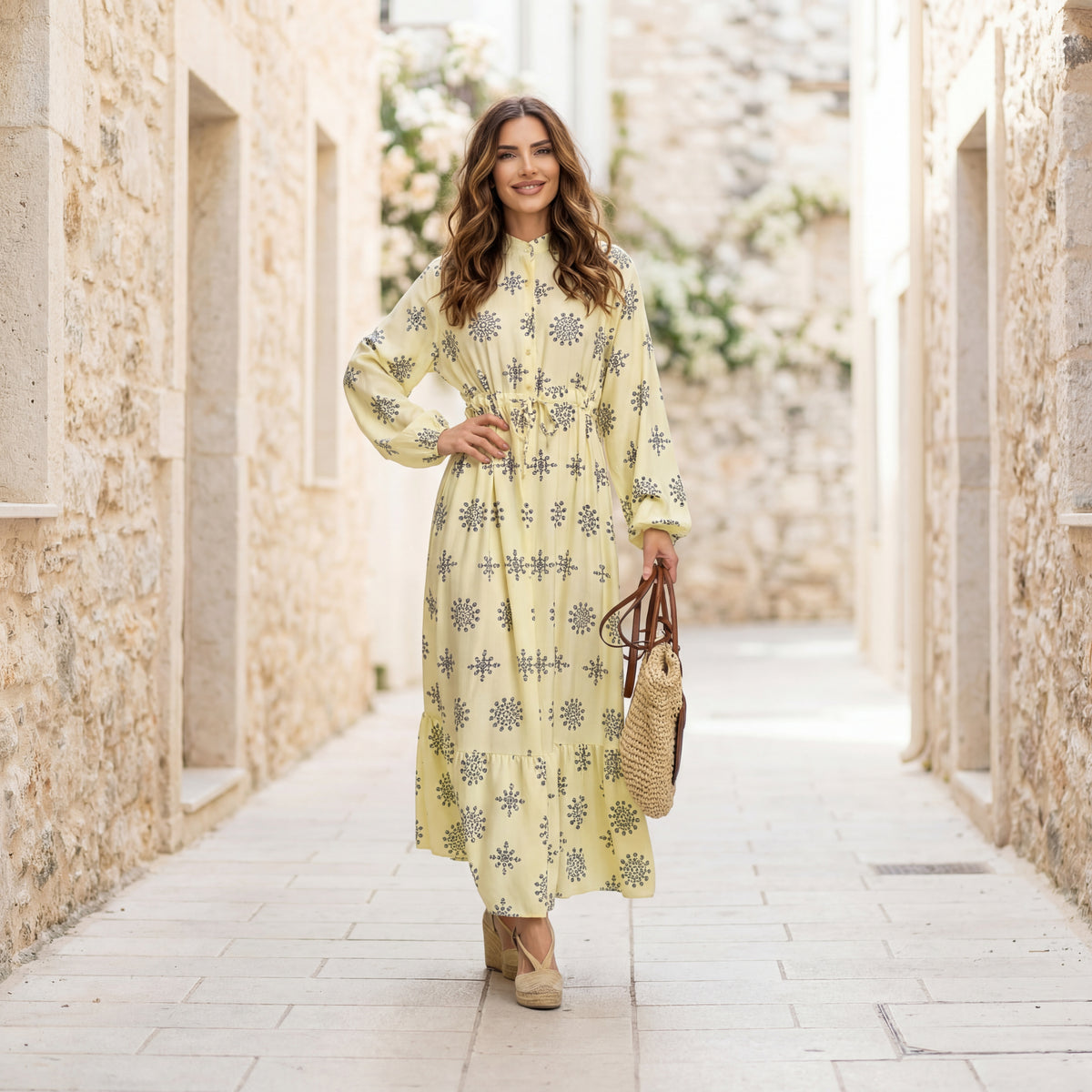 Pastel yellow printed maxi dress with long sleeves worn outdoors