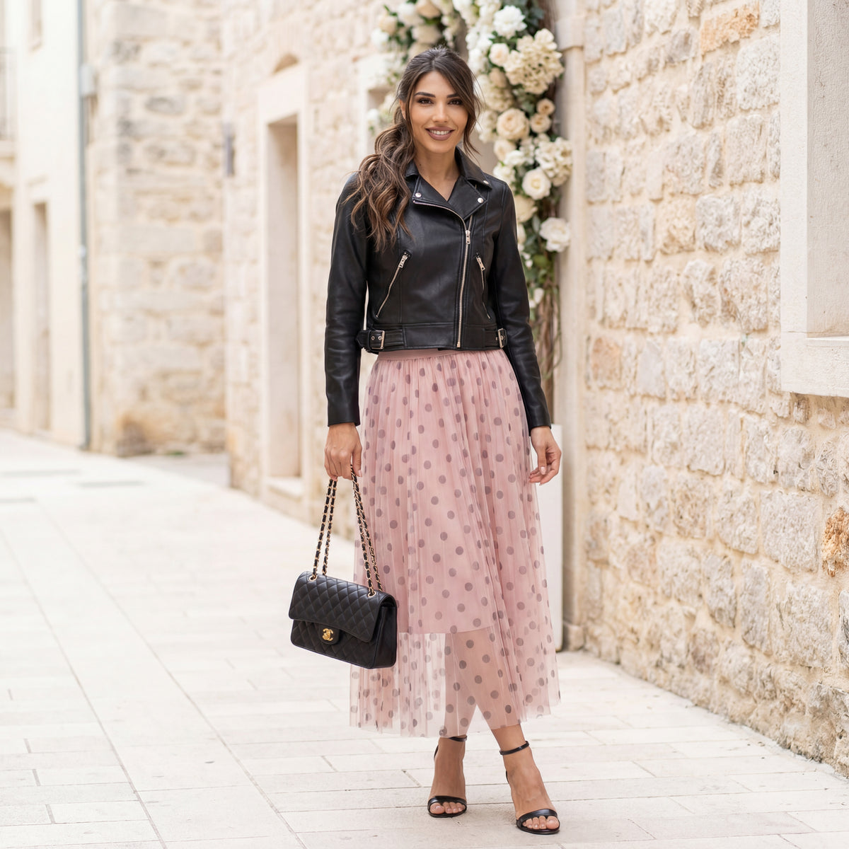 Rose tulle polka dot midi skirt worn outdoors with leather jacket