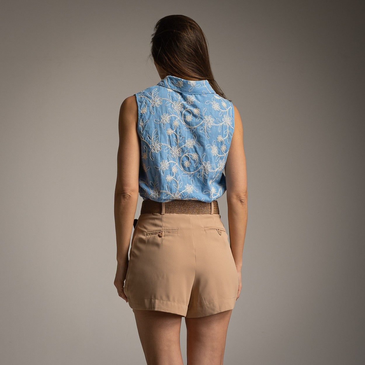 Back view of a sleeveless embroidered floral blouse in sky blue with elegant all-over floral embroidery details.