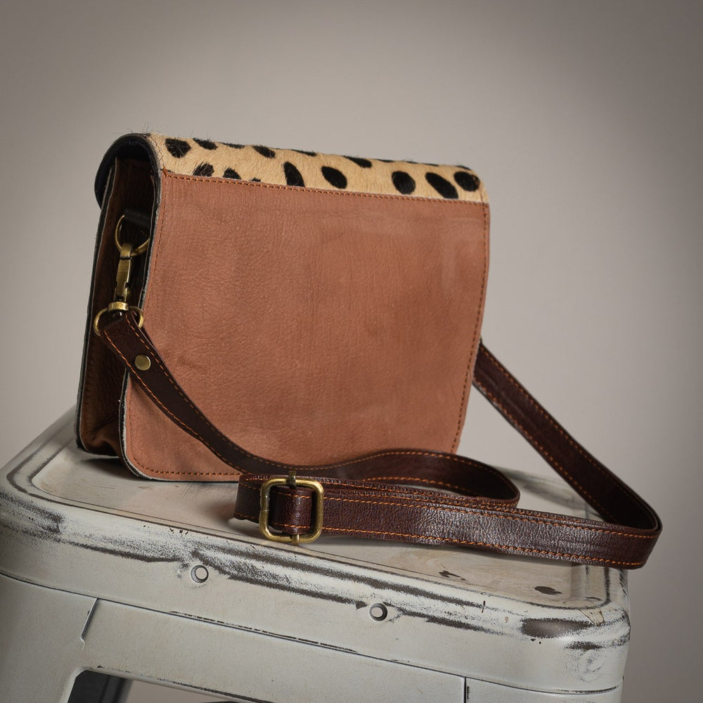 Brown leather back view of spotted crossbody bag with adjustable strap