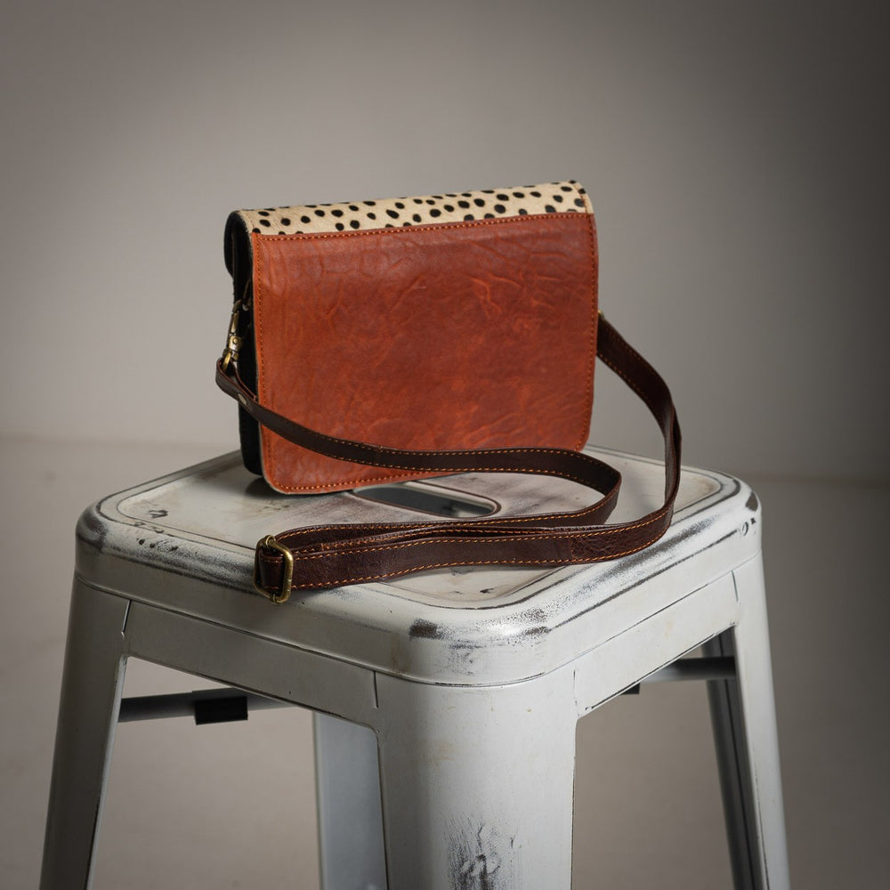 Brown leather back view of compact spotted crossbody bag