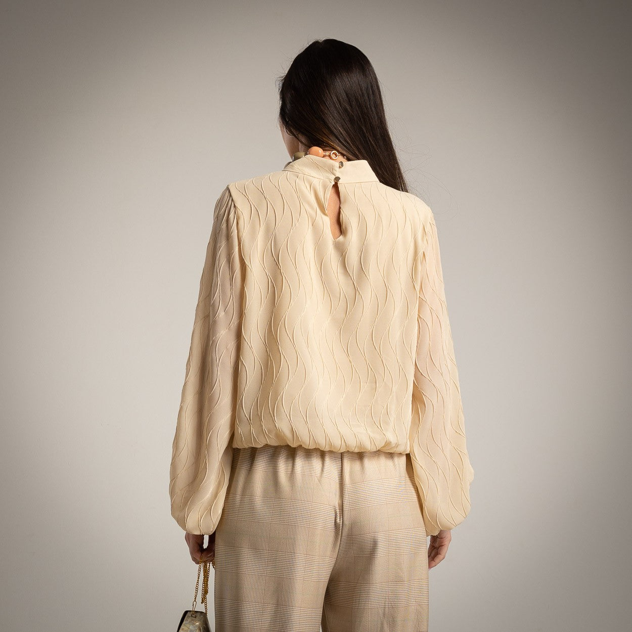 Back view of beige textured wave blouse with soft drape – MARIΓIOÚ