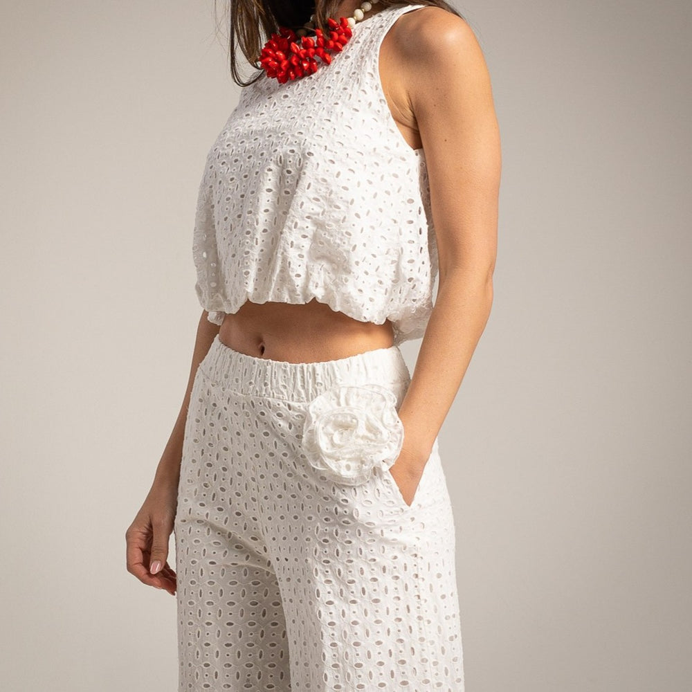 White broderie anglaise sleeveless top and wide leg pants set with floral waist detail and red accessories